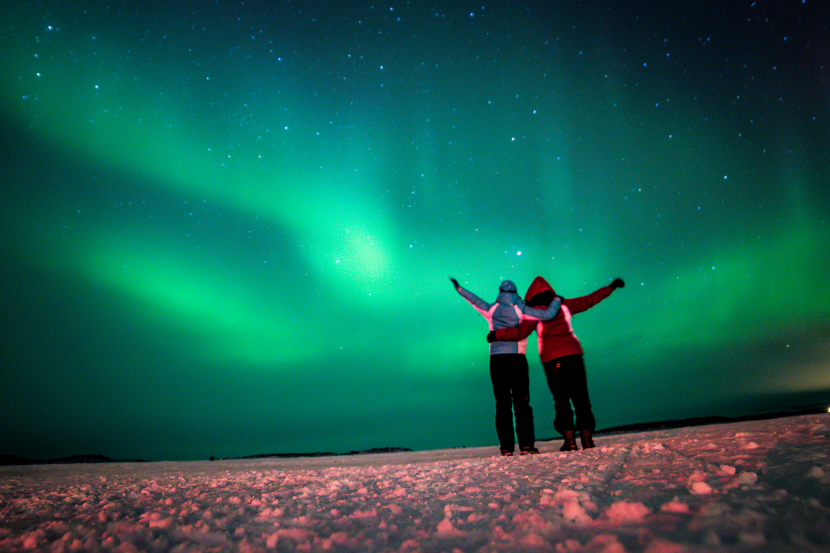 Travelers observe the Northern Lights during winter
