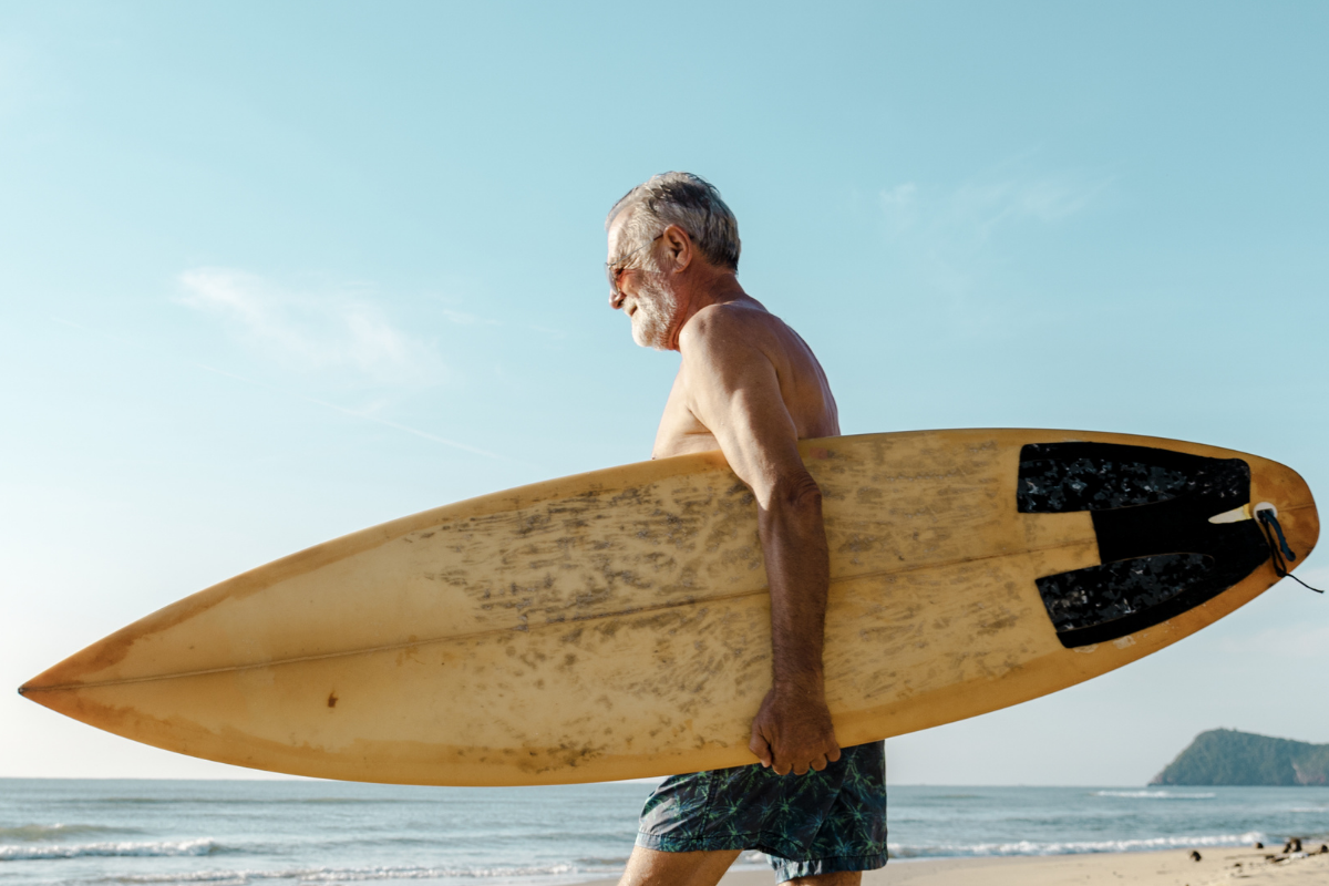 Older person heads out to surf.
