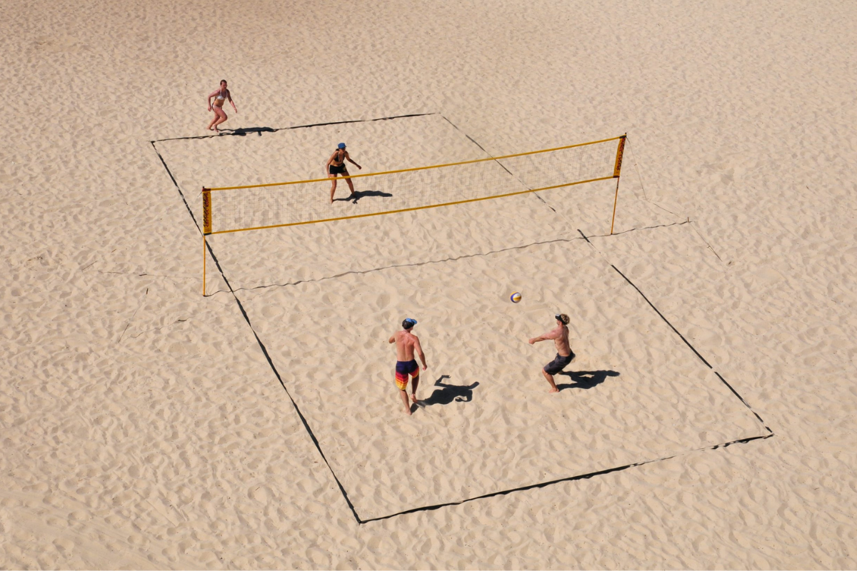 Adults playing a beach game of volleyball.