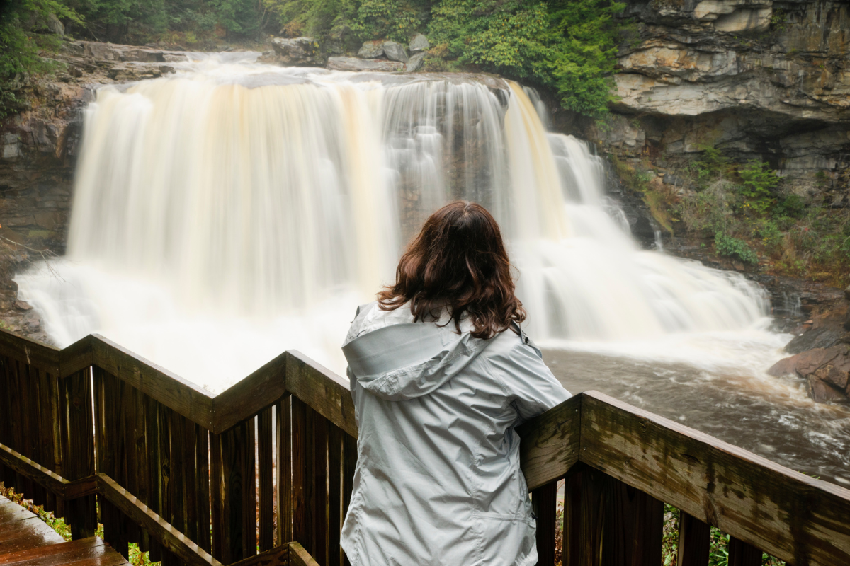Woman admiring the Blackwater Falls located in the state park by the same name in West Virginia. blackwater falls state park west virginia