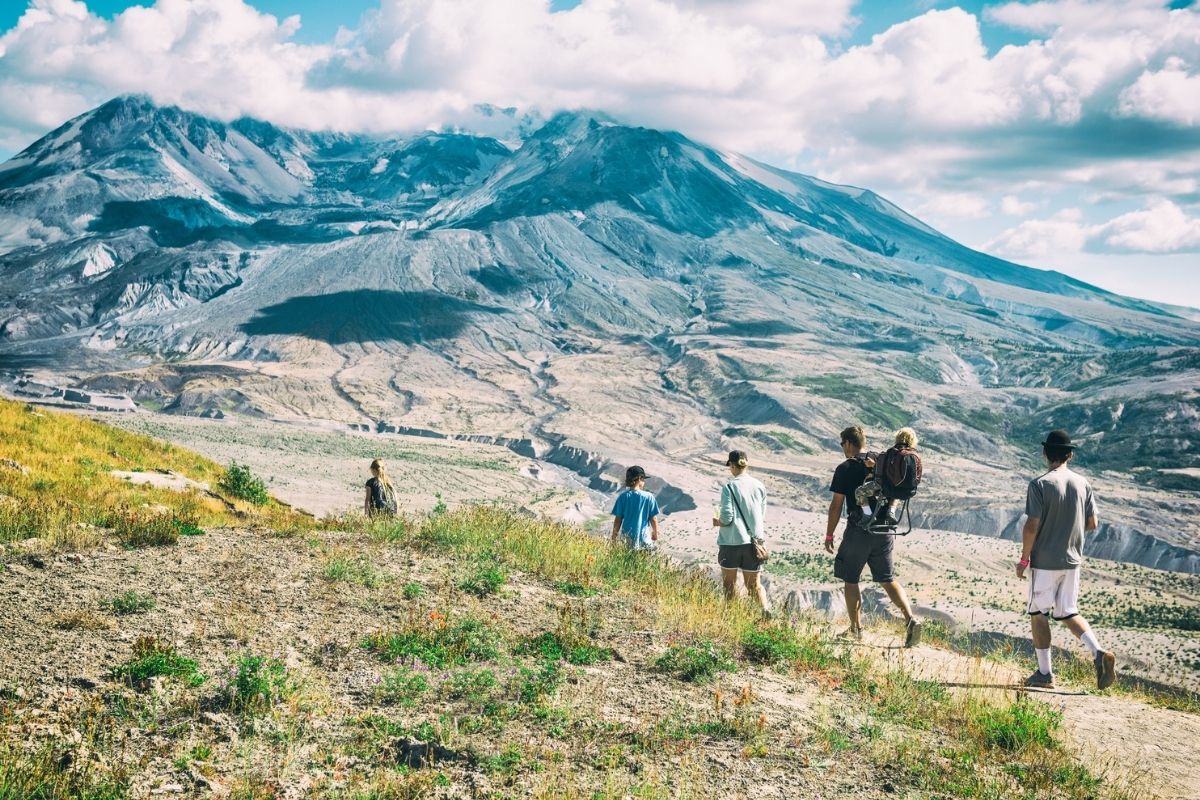 An extended family hikes and enjoys the beautiful mountain views around Mt Saint Helen in the National Park. Family takes selfies, points and discusses views, and walks in nature.