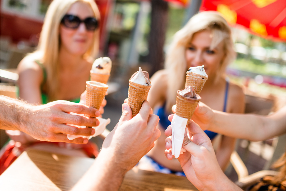 group of friends eating icecream on summer in swimwear