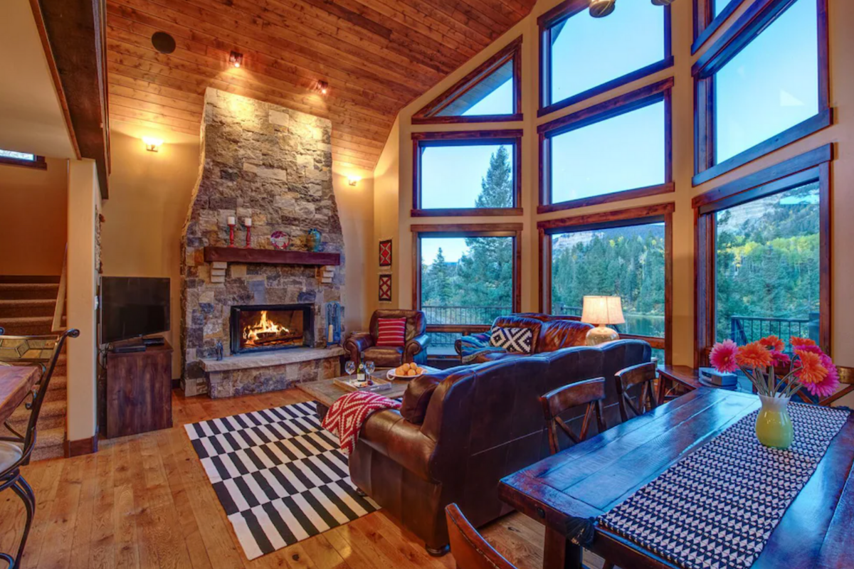 living room of a vast cabin living room with wilderness in window