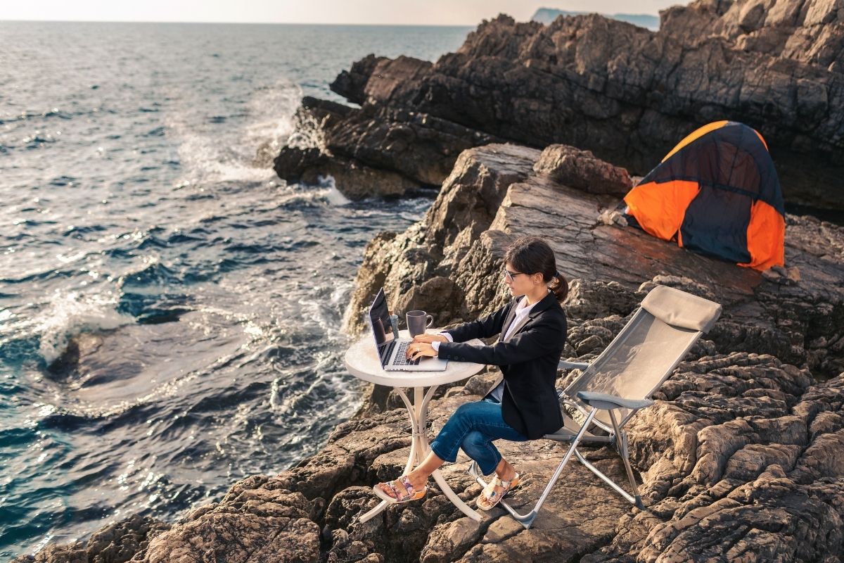Business woman working from the beach. Working from distance concept. Freelancer travel and work online.